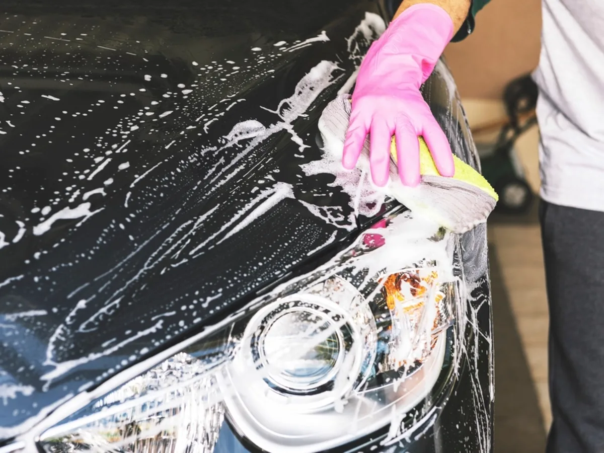 Eingeschäumte Fahrzeugfront wird von Hand gewaschen